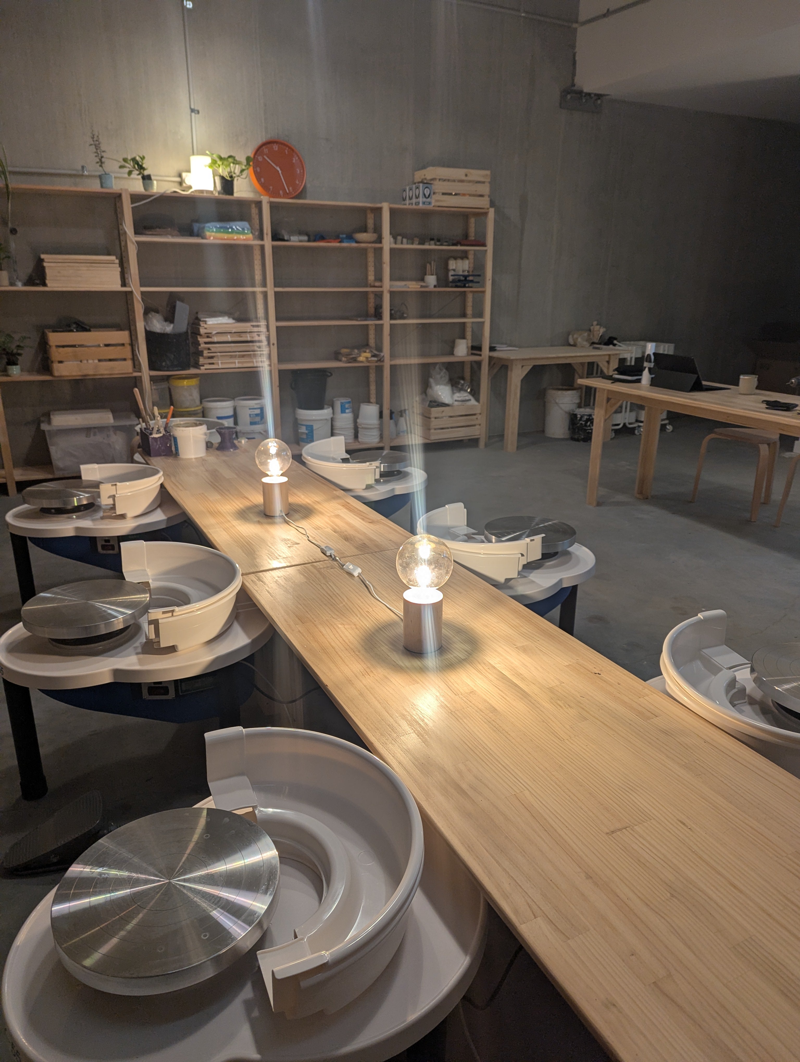 Dining area with wooden table and chairs, shelves in the background